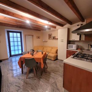 une cuisine et un salon avec une table et un canapé dans l'établissement Il Cortiletto Mountain Lake Iseo Hospitality, à Costa Volpino