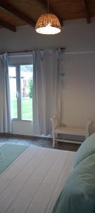 a bedroom with a window and a bed and a lamp at ALOJAMIRAMAR in Miramar