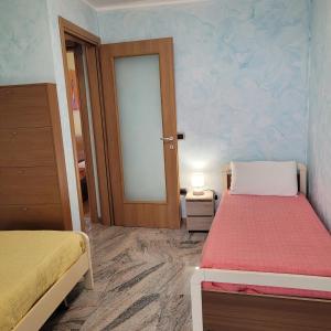 een kamer met 2 bedden en een deur naar een slaapkamer bij Il Cortiletto Mountain Lake Iseo Hospitality in Costa Volpino