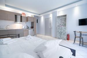 una camera con letto bianco e una cucina di Kastella cozy flat for 2 persons my MPS a Pireo