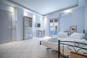 een witte slaapkamer met een bed en een tafel bij Kastella cozy flat for 2 persons my MPS in Piraeus