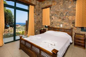 a bedroom with a bed and a large window at Amazing sea views at villa Elafonissi with private pool, near Elafonissi beach in Chania