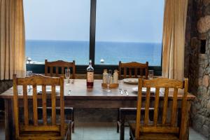 a table with chairs and a bottle of wine on it at Amazing sea views at villa Elafonissi with private pool, near Elafonissi beach in Chania