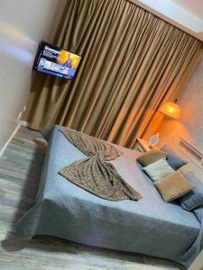 - une chambre avec un grand lit et une télévision murale dans l'établissement Nador Holiday, à Selouane