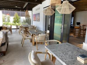 モハカルにあるSPECTACULAR APRT. IN FRONT OF THE SEAの木製のテーブルと椅子、テーブルと椅子が備わるレストラン