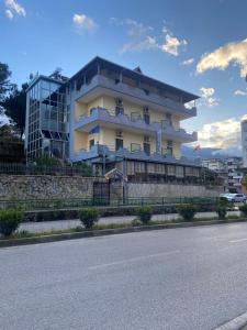ein großes Gebäude am Straßenrand in der Unterkunft Qiqi Hotel in Gjirokastër