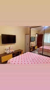ein Hotelzimmer mit einem Bett und einem großen Spiegel in der Unterkunft Dunas Apartamento in Cabo Frio