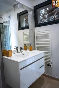 La salle de bains blanche est pourvue d'un lavabo et d'un miroir. dans l'établissement VILLA ROCCA BRUNA, LE CAP CORSE 5 ETOILES, à Santa-Maria-di-Lota