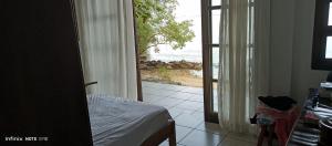 Schlafzimmer mit einer Tür und Meerblick in der Unterkunft Paraíso da ilha in Paranaguá