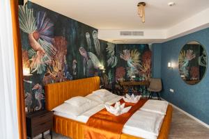 Un dormitorio con una cama grande con flores. en Hotel Atlantis Wellness & Conference, en Hajdúszoboszló