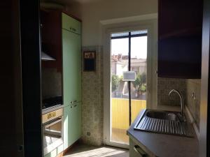 a kitchen with a green door and a sink at Casa Ellie - casa vacanze con giardino e posto auto privati in Grado