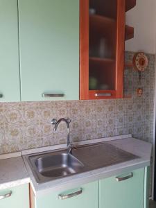 a kitchen counter with a sink and a cabinet at Casa Ellie - casa vacanze con giardino e posto auto privati in Grado