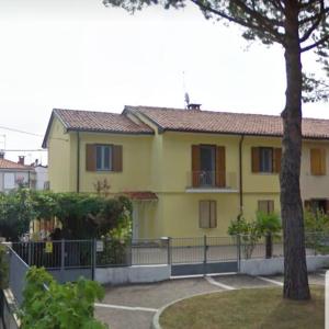 a yellow house with a fence in front of it at Casa Ellie - casa vacanze con giardino e posto auto privati in Grado