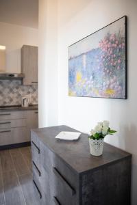 une cuisine avec une table et un tableau mural dans l'établissement Gray Pearl - modern apartment in the city center, à Arona