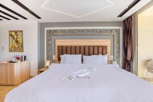 um quarto com uma grande cama branca e uma cabeceira em madeira em Diamond pyramids hotel em Cairo