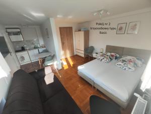 a bedroom with a bed and a living room at Apartamenty Monterska in Bielsko-Biała