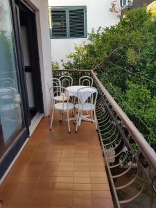 un balcón con mesa y sillas. en Apartman Lili Podgora, en Podgora