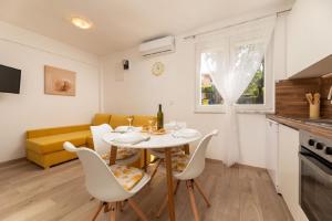 a kitchen and living room with a table and chairs at Ferienwohnung für 4 Personen ca 50 qm in Njivice, Kvarner Bucht Krk in Njivice +14 photos