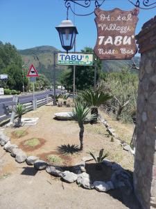 a street sign and signs on the side of a road at Hotel Villaggio Tabù in Palinuro