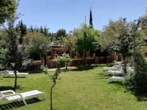 a row of white park benches in the grass at Hotel Villaggio Tabù in Palinuro