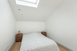 a white bedroom with a bed and a window at Bel Appartement climatisé proche Paris et Disneyland in Saint-Maur-des-Fossés