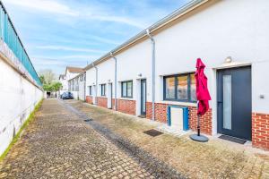 a row of houses with a red umbrella on a street at Bel Appartement climatisé proche Paris et Disneyland in Saint-Maur-des-Fossés