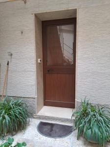 uma porta de madeira de uma casa com duas plantas em la casa del nonno em Trapani