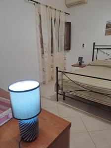 um quarto com uma cama e um candeeiro sobre uma mesa em la casa del nonno em Trapani