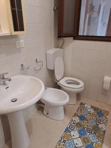 uma casa de banho com um WC branco e um lavatório. em la casa del nonno em Trapani