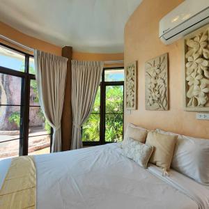 a bedroom with a large white bed with windows at ฺBuena Vista Pool Villa Hua Hin (บ้านพักหัวหิน) in Hua Hin