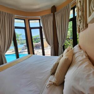 a bedroom with a bed with a view of a pool at ฺBuena Vista Pool Villa Hua Hin (บ้านพักหัวหิน) in Hua Hin