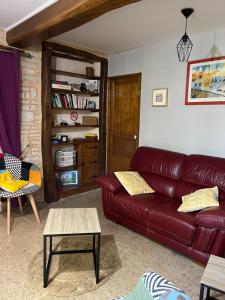 ein Wohnzimmer mit einem roten Ledersofa in der Unterkunft Les Belles Fontaines in Bierry-les-Belles-Fontaines