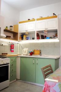 a kitchen with green and white cabinets and a table at Lithi Stylish Apartments- Cosy in Tripiti