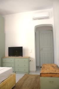 a bedroom with a bed and a tv on a dresser at Lithi Stylish Apartments- Cosy in Tripiti