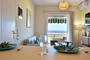 a dining room table with two plates and a glass of wine at Two-bedroom Condo with Sea View in Glyfada in Glyfada
