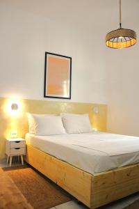 Cette chambre comprend un lit avec un cadre en bois. dans l'établissement Lithi Stylish Apartments- Cosy, à Trypiti