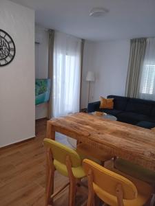 a living room with a wooden table and chairs at TINAME in Ražanac