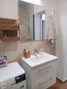 a white bathroom with a sink and a mirror at TINAME in Ražanac