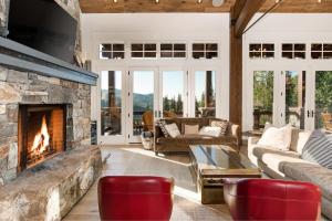 een woonkamer met een stenen open haard en rode stoelen bij The Finest Expression of Mountain Homes, Ski In Out, Hot Tub in The Colony in Park City