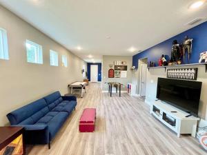 a living room with a blue couch and a tv at The Billiard close to downtown with fenced yard in Sanford