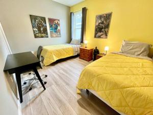 a bedroom with two beds and a desk in it at The Billiard close to downtown with fenced yard in Sanford