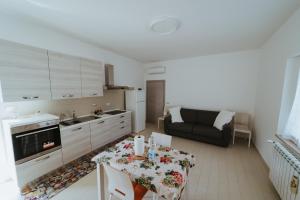 a kitchen and living room with a table and a couch at A due passi dal mare - Oasi di pace in Petacciato