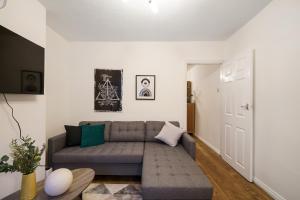 een woonkamer met een bank en een tafel bij Harry Potter Experience - 3 Bed House In Watford in Watford