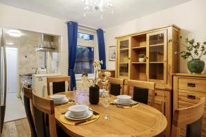 a dining room with a wooden table and chairs at Harry Potter Experience - 3 Bed House In Watford in Watford