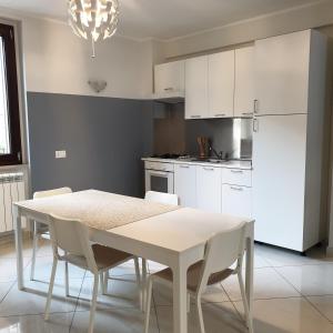a white kitchen with a table and white cabinets at Il campanile in Montecilfone