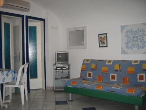 a living room with a couch and a tv at L'Isolana Case Vacanza Alloro 2 in Ponza
