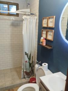 a bathroom with a shower curtain and a toilet at The Yellow House Boquete (hostal) in Alto Boquete