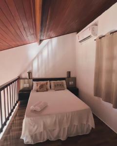 a bedroom with a large bed with white sheets at Pipa Golfinhos Pousada in Pipa