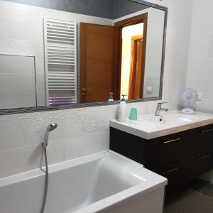 ein Badezimmer mit einer Badewanne, einem Waschbecken und einem Spiegel in der Unterkunft Il campanile in Montecilfone