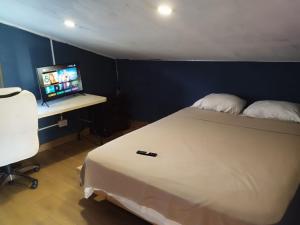 um quarto com uma cama e uma secretária com um computador em The Yellow House Boquete (hostal) em Alto Boquete